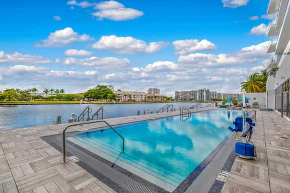 Enjoy the serene waterfront pool overlooking the calm canal. Swim or relax on loungers while watching boats pass by, a tranquil spot to unwind after a day of exploring.