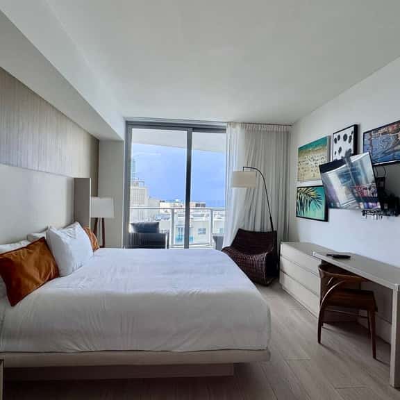 Step into a serene retreat with a plush king bed, modern décor, and floor-to-ceiling windows opening to a private balcony with city and ocean views. The en-suite bathroom also connects to the living room for added convenience.