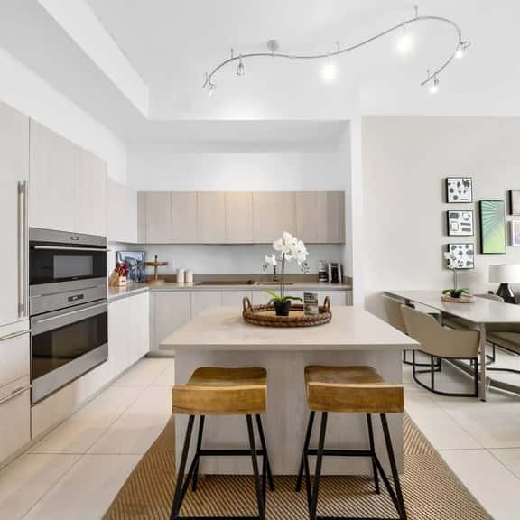 This kitchen features a spacious island with seating for two, modern appliances, and ample counter space - perfect for cooking meals or enjoying a casual breakfast in a bright, open setting.